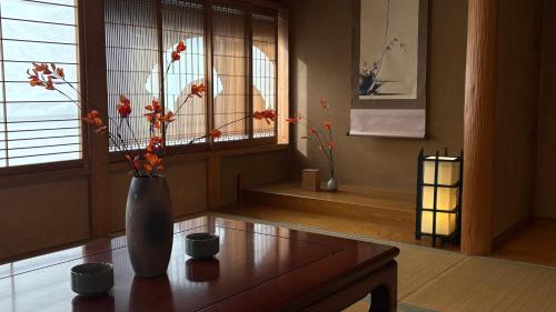 Un jarrón con flores sobre una mesa en una habitación. en ザホテル湯沢パラディーソ, en Yuzawa