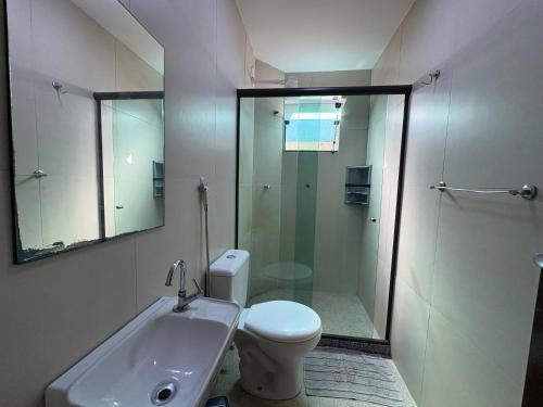 a bathroom with a shower and a toilet and a sink at Recanto Praia Grande in Arraial do Cabo