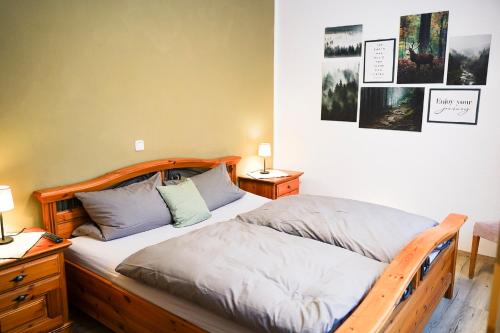 una camera con letto in legno e 2 cuscini di Restaurant - Garni bei Peppo a Ebern