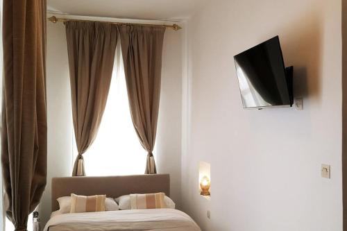 um quarto com uma cama e uma televisão na parede em Riad de charme l'Oasis d'Essaouira - Suite Luxe em Essaouira