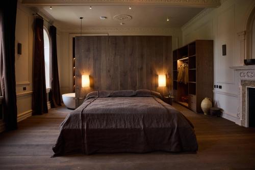 a bedroom with a large bed and a bath tub at The Coach House Lodges at Denton Reserve in Denton