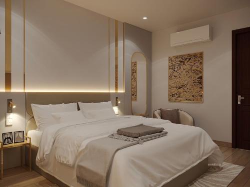 a bedroom with a large white bed and a chair at MAYS Grand Hotel & Spa - Ben Thanh in Ho Chi Minh City