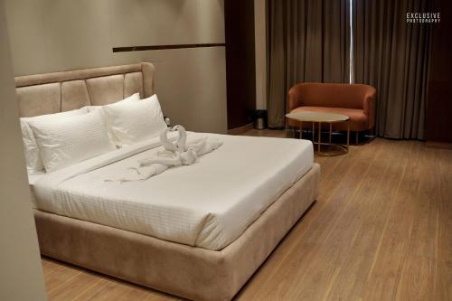 Majestic Castle في لوديانا: غرفة نوم بسرير ابيض وكرسي