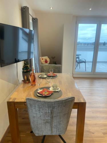 mesa de comedor con TV en la pared en Ferienwohnungen Zimmermann, en Bad Waldsee