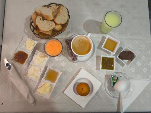 Al MadīnahにあるHôtel EDHIAFAの朝食の食べ物とジュースのグラスが置かれたテーブル