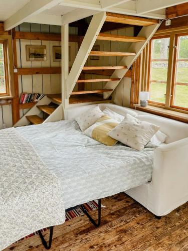 Renovated Cottage By Lake Rydbos في ألينغساس: غرفة نوم بسرير ابيض ودرج