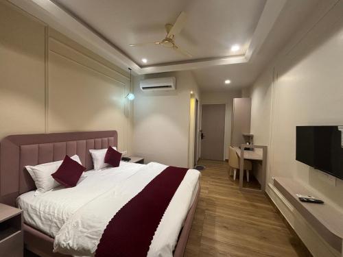 een slaapkamer met een bed, een bureau en een televisie bij Hotel Shree Rajasthan Inn in Ajmer