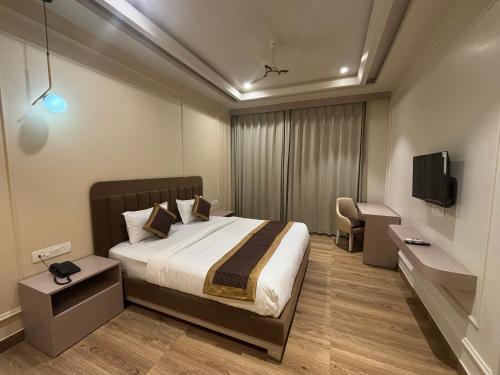 een hotelkamer met een bed en een tv bij Hotel Shree Rajasthan Inn in Ajmer