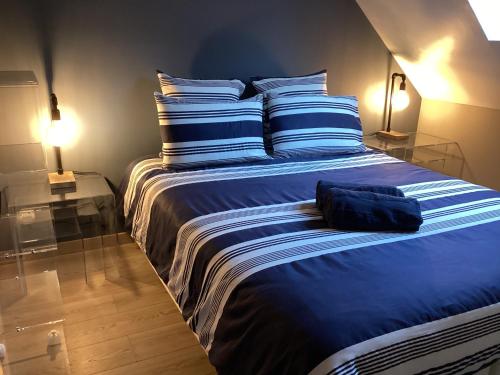 a bedroom with a large bed with blue sheets at L'Eugenie in Pierrefonds
