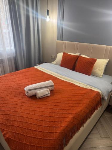 una camera da letto con un letto con asciugamani sopra di Designer apartment opposite the Airport a Almaty
