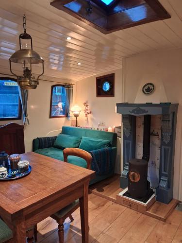 un soggiorno con divano verde e camino di Klipper Engelburg a Zwolle