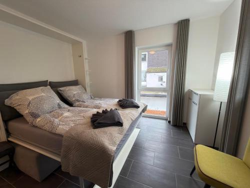 Un dormitorio con una cama y una ventana en FeWoMo Premium Mosel Fewo an der Promenade in Cochem mit Burgblick barrierefrei bis 6 Personen, en Cochem