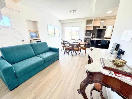 een woonkamer met een blauwe bank en een tafel bij Blu Mare Casa Vacanza in La Maddalena