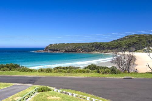 un camino vacío junto a una playa con el océano en Surfside, en Kioloa