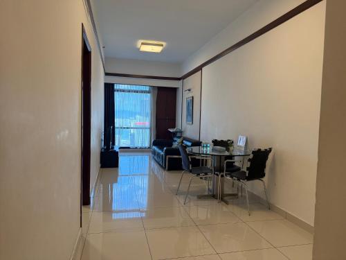 un soggiorno con un tavolo e un divano di Maju Suites Berjaya Times Square a Gua Sai