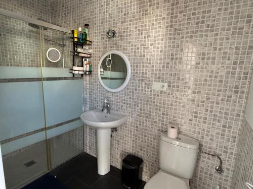 ein Badezimmer mit Waschbecken, Toilette und Spiegel in der Unterkunft Sunshine Studio Retreat in Arboleas in Arboleas