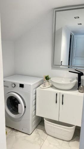 a white bathroom with a washing machine and a sink at Le Paradisblanc in Kelibia