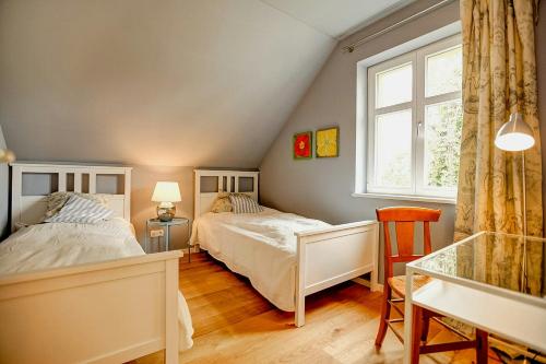 Un dormitorio con dos camas y un escritorio y una ventana. en Natur Erleben Im Ländlichen Gästehaus An Der Havel, en Paretz