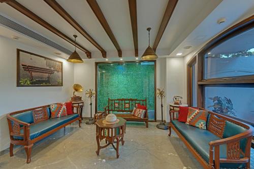 ein Wohnzimmer mit Sofas, einem Tisch und einem Fenster in der Unterkunft Comfort Inn Emerald in Dapoli