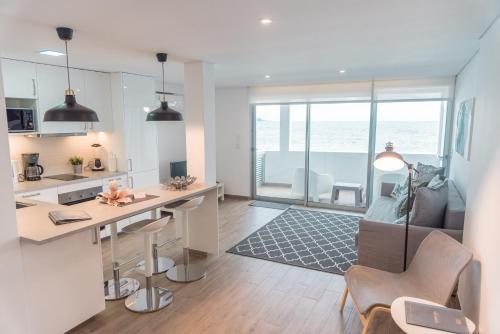 a kitchen and living room with a table and chairs at Islet House in São Roque