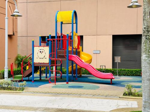 un parco giochi con scivolo di fronte a un edificio di Maju Suites Berjaya Times Square a Gua Sai