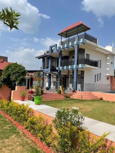 een groot wit gebouw met balkons en een tuin bij The time's stay in Nāi