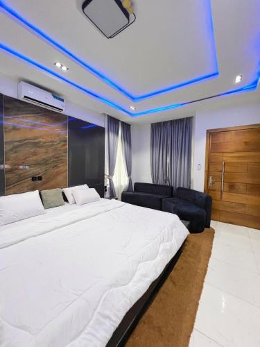 a bedroom with a large white bed and a couch at Casa Lumière in Lekki