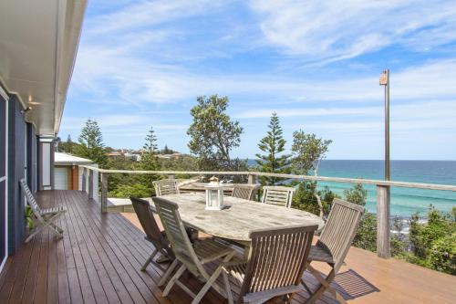 a deck with a table and chairs and the ocean at Sticks by the Sea - pet-friendly coastal home in Manyana