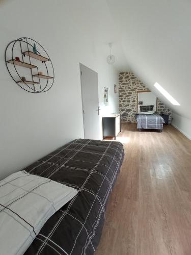 a bedroom with a large bed and a stone wall at Entre Dômes et Sancy - Le moderne in Perpezat