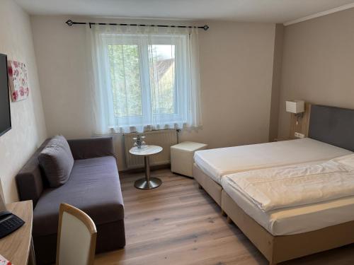 a small bedroom with a bed and a couch at Hotel Central in Zeven