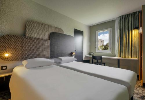 Postel nebo postele na pokoji v ubytování B&B HOTEL Niort Sud Venise Verte