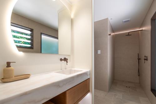 a bathroom with a sink and a mirror at NALA Resort in Mission Beach