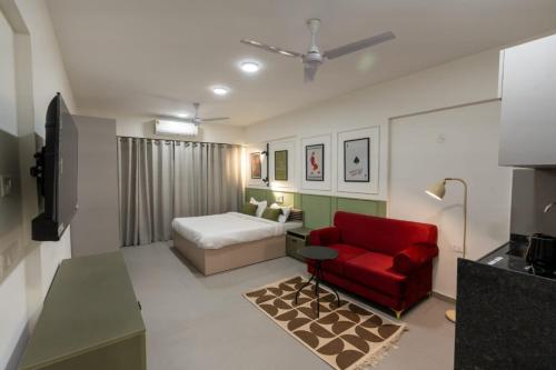 a bedroom with a bed and a red chair at House of KP by Union in Pune