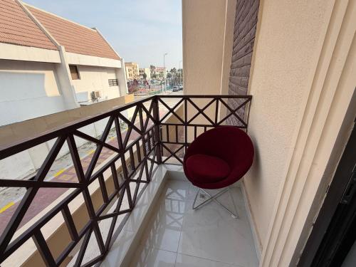 a red chair sitting on the balcony of a building at Khalidiya Studio in Abu Dhabi