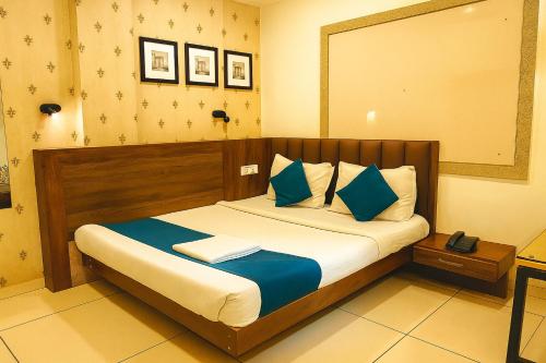 a bedroom with a bed with blue and white pillows at Hotel Shree Ram Palace in Indore