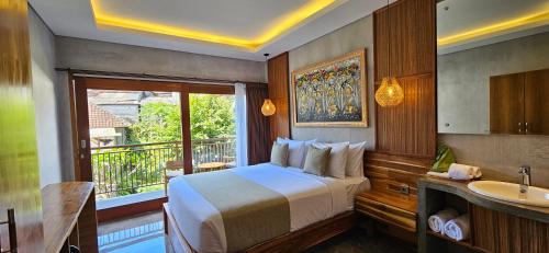 a bedroom with a bed and a sink and a window at Dhanyasari House in Ubud
