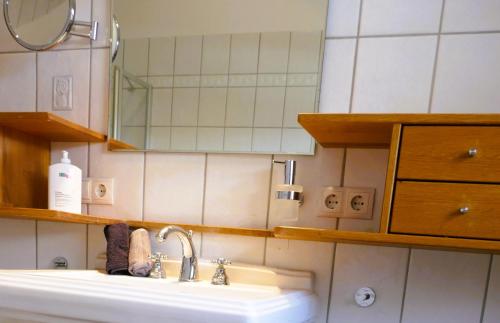 a bathroom with a sink and a mirror at Bodenschneidsuiten Das Gschwandler in Tegernsee