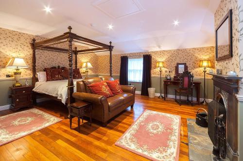 a bedroom with a bed and a couch and a chair at The George Hotel in Inveraray