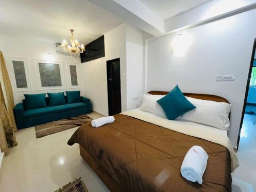 a bedroom with a large bed and a blue couch at Villa platinum 4 BHK Calangute in Calangute