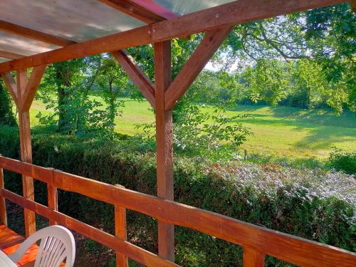 les chalets d'alzen في Alzen: شرفة خشبية مطلة على حقل