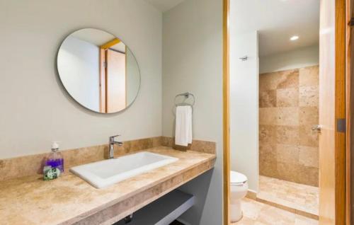a bathroom with a sink and a mirror and a toilet at Kamya cottage in New Delhi