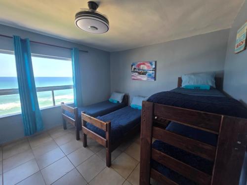 een slaapkamer met 2 bedden en een raam met uitzicht op de oceaan bij Amanzi 1305 in Vosburg