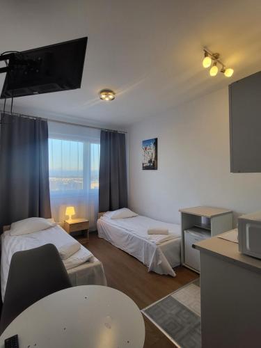 a hotel room with two beds and a television at VESTA Apartamenty P23 in Szczecin