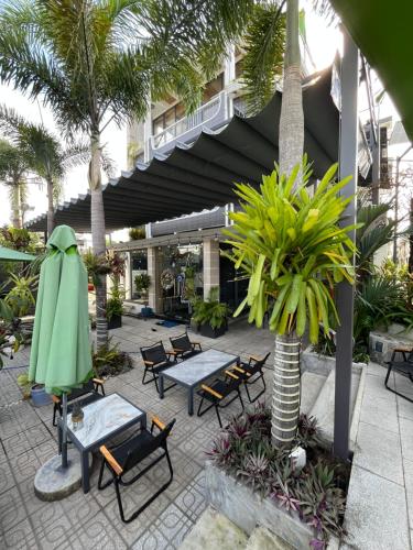 Tây NinhRooftop villa hien dai 2 người的一个带桌椅的庭院,棕榈树