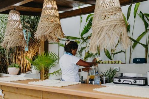 a chef preparing food at a counter in a kitchen at Les Villas Mandju in Sainte-Rose