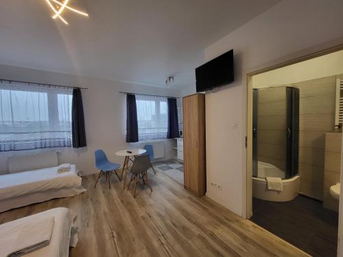 ein Schlafzimmer mit einem Bett und einem Tisch sowie ein Badezimmer in der Unterkunft VESTA Apartamenty P23 in Stettin