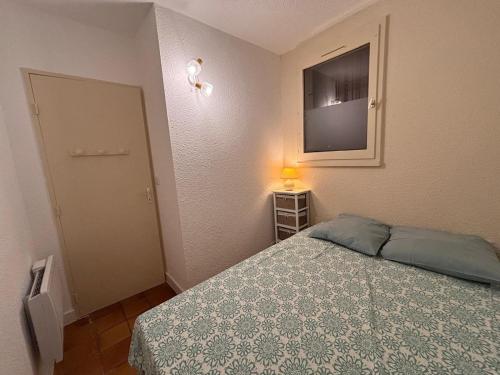 een slaapkamer met een bed en een televisie aan de muur bij Tokelau - Vue Mer in Sausset-les-Pins