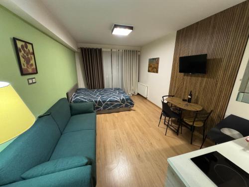 un soggiorno con un divano blu e un letto di New Gudauri Studio a Gudauri