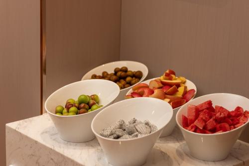 un grupo de cuencos de fruta en un mostrador en ELong Hotel 艺 龙 酒 店 - Guilin Elephant Trunk Hill Scenic Area Two Rivers and Four Lakes Branch, en Guilin