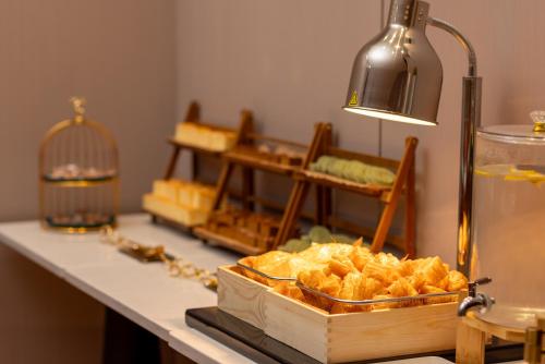 Un mostrador con algo de pan en una caja sobre una mesa. en ELong Hotel 艺 龙 酒 店 - Guilin Elephant Trunk Hill Scenic Area Two Rivers and Four Lakes Branch, en Guilin